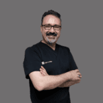 a man with glasses and a beard wearing a black shirt